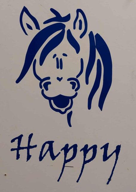 En blå teckning av ett hästhuvud med texten "Happy" under.